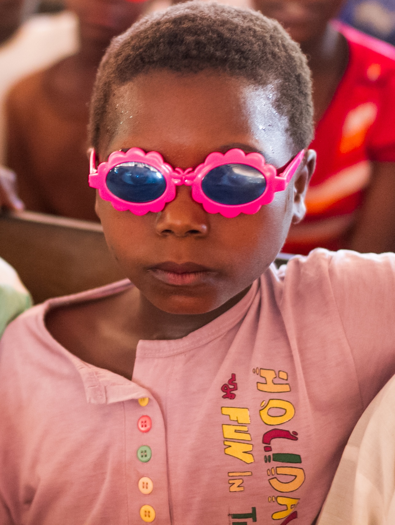 A girl wears a pair of sunglasses.