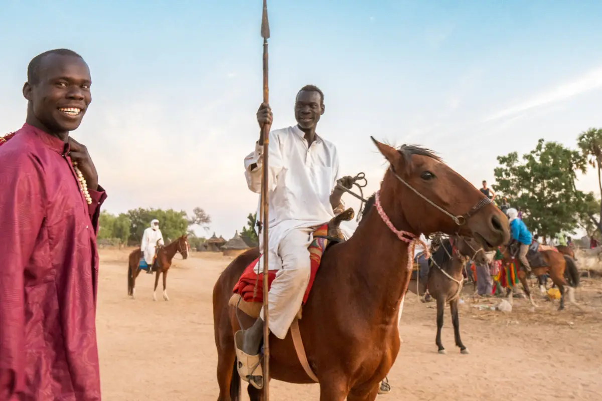 Maenner im Tchad mit Pferd